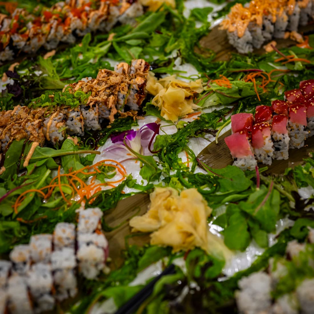 Overhead view of an abundant sushi spread with garnishes.