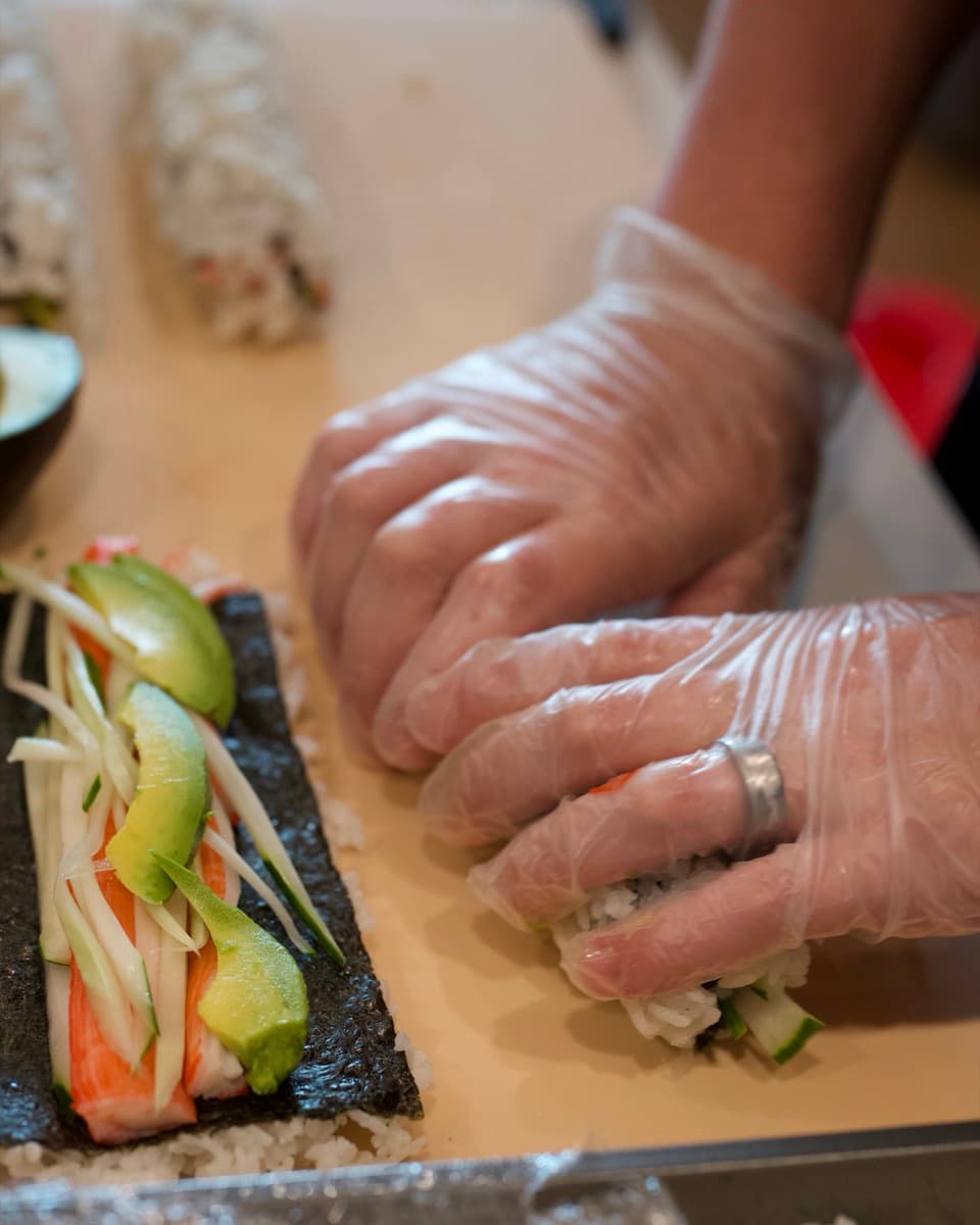 Rolling a vegetable roll by hand at a private Sonakase event.