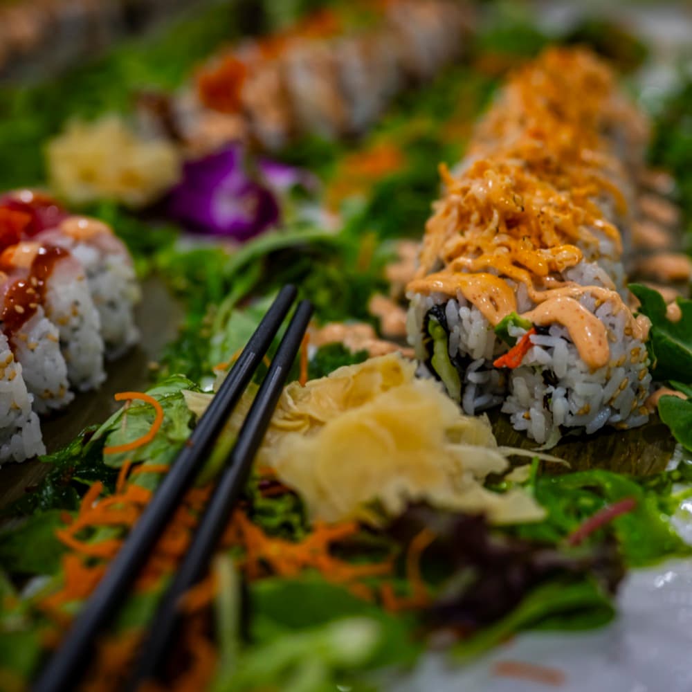A lineup of freshly cut sushi rolls plated for a dinner party.