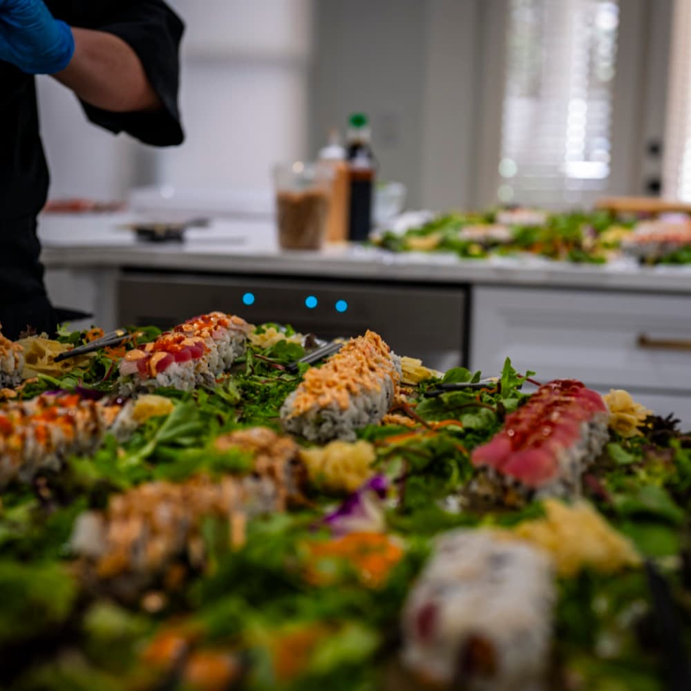 A full sushi spread across the kitchen counter at an in-home event.