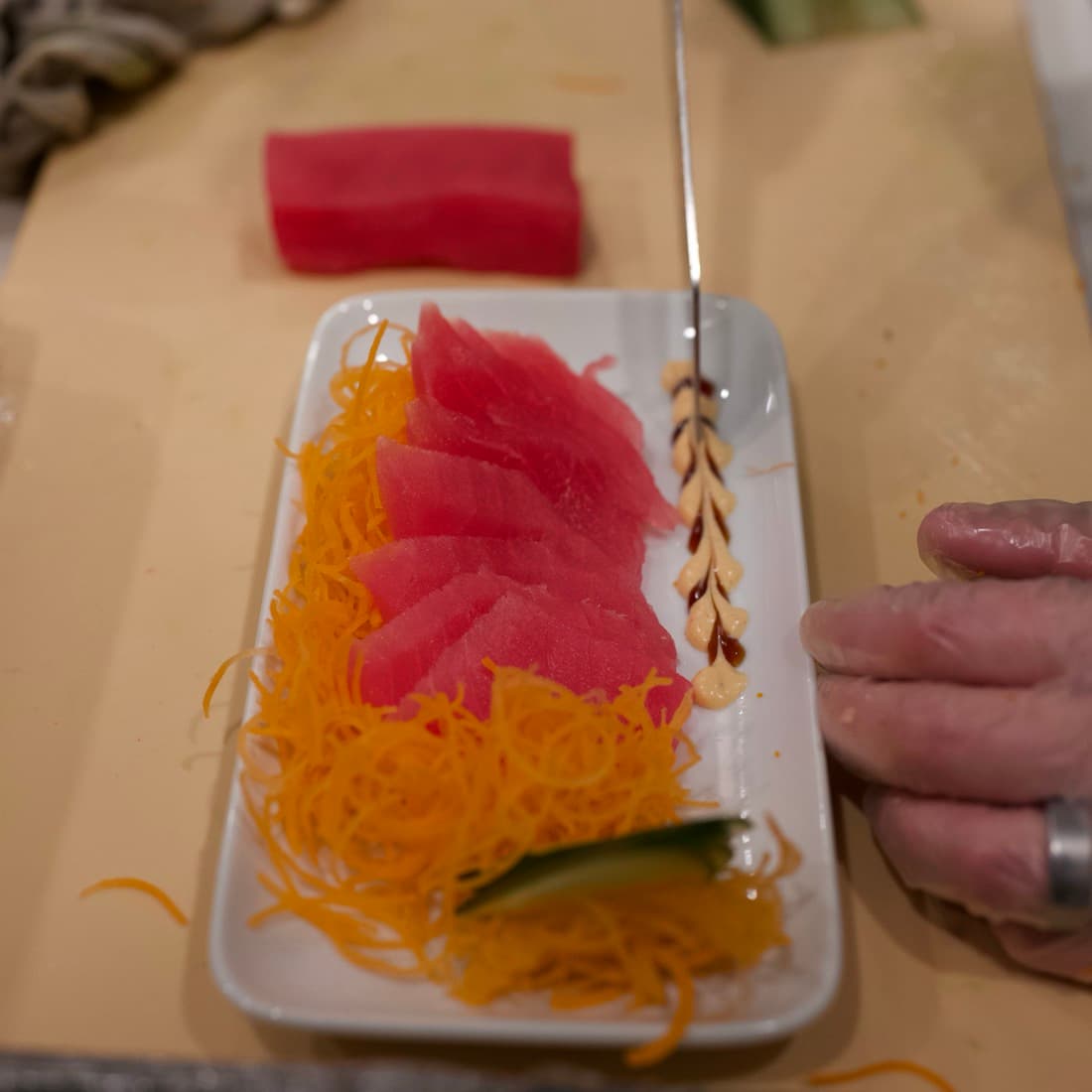 Fresh tuna sashimi cut and plated over shredded carrot.